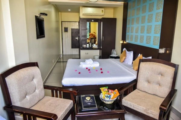 Hotel room with double bed, chairs and bedside table